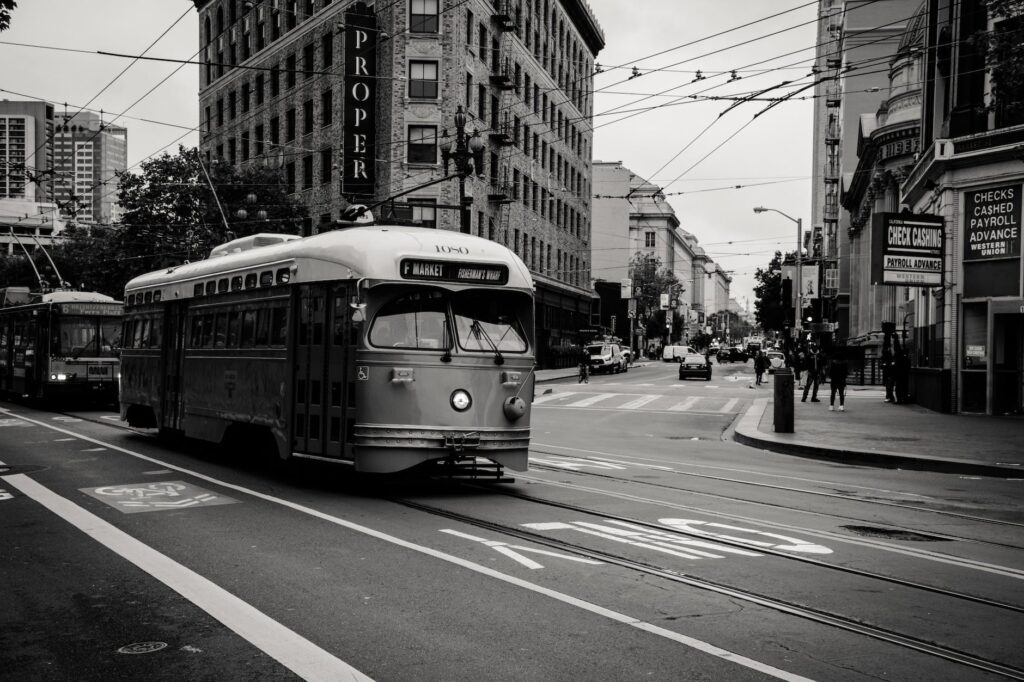 grayscale photography of tram near buildings