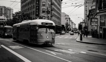 grayscale photography of tram near buildings