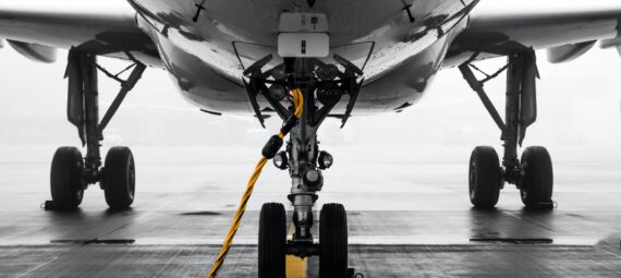 gray air vehicle with yellow coated cable around docking wheels