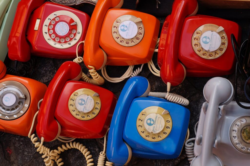 seven assorted colored rotary telephones