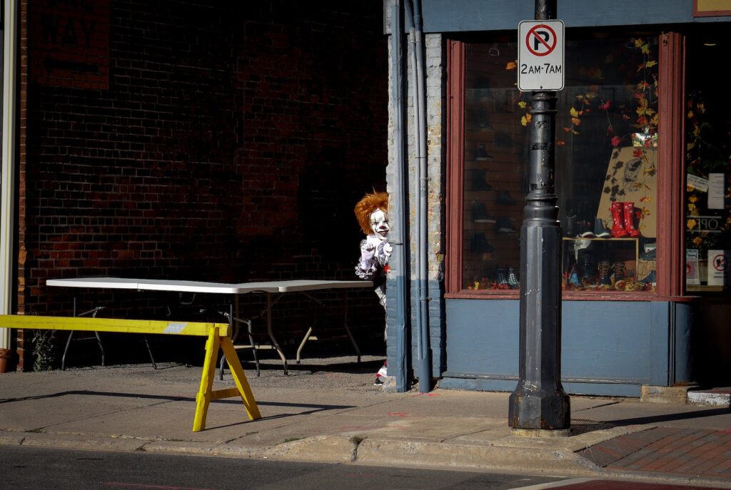 a person in clown costume outside a wall of a store