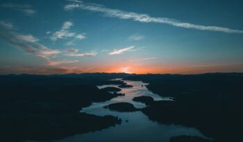 aerial photography of water beside forest during golden hour