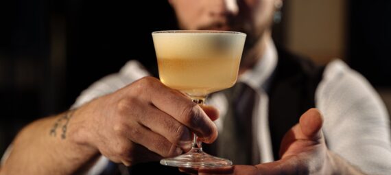 a bartender holding a cocktail drink