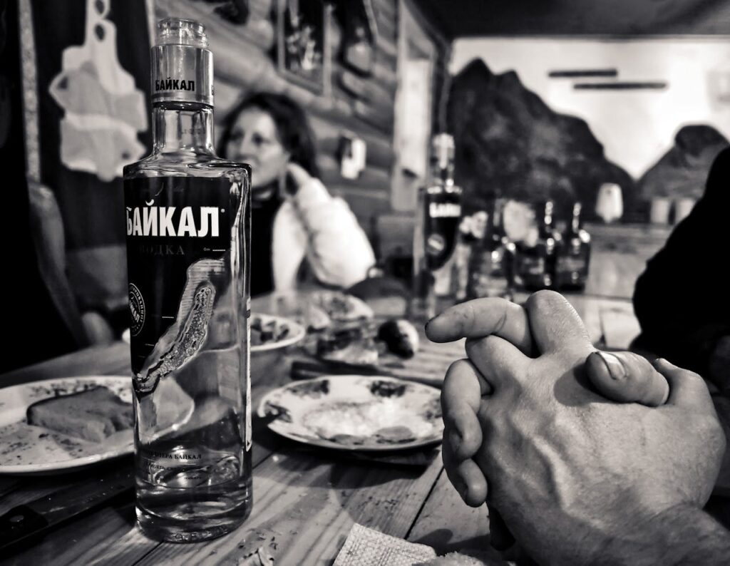 photo grayscale photography of bottle beside saucer