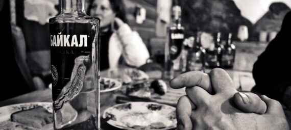 photo grayscale photography of bottle beside saucer