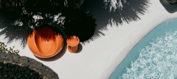 https://www.pexels.com/photo/photo-of-a-seat-next-to-a-swimming-pool-15173066/